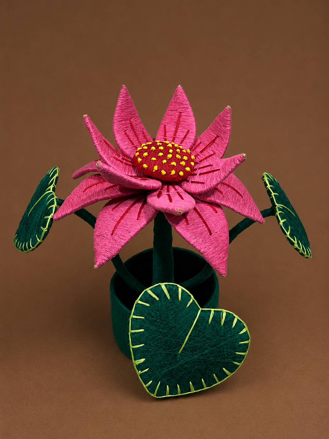 Handcrafted coir lotus flower pot made from natural coconut fibre with green leaves and pink lotus petals.