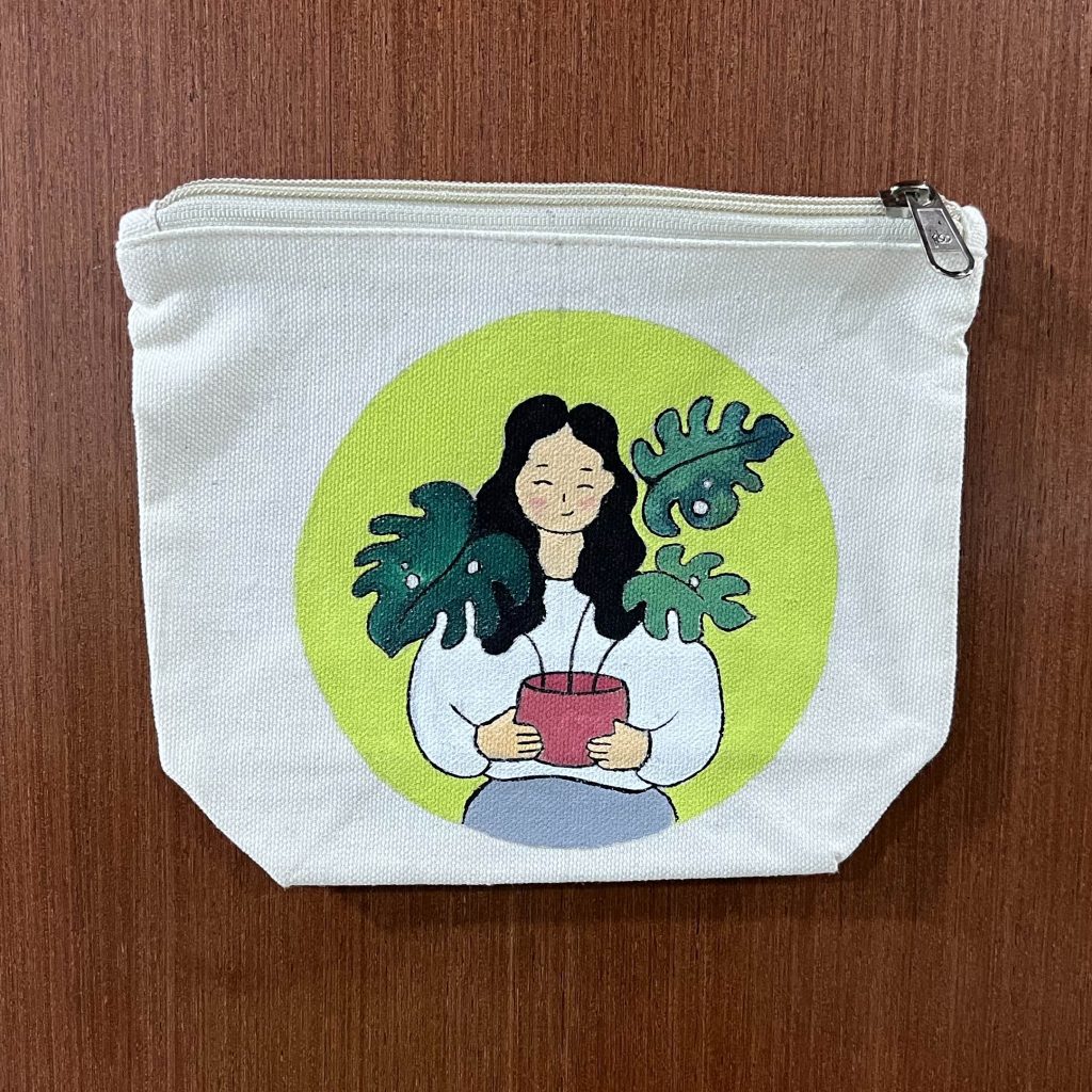 Hand-Painted Botanical Girl Canvas Pouch featuring a girl holding a potted plant surrounded by lush green leaves